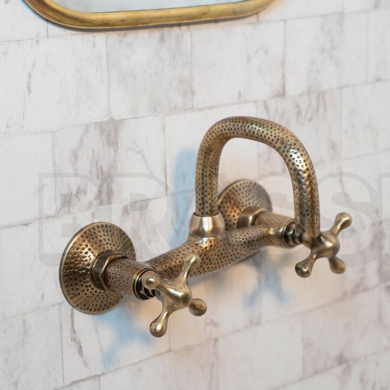 Hand-hammered brass wall mount bathroom faucet with oil-rubbed finish and vintage cross handles
