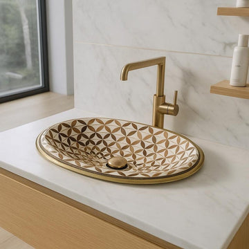 Handmade oval brass bathroom sink with bone and wood floral inlay on white base