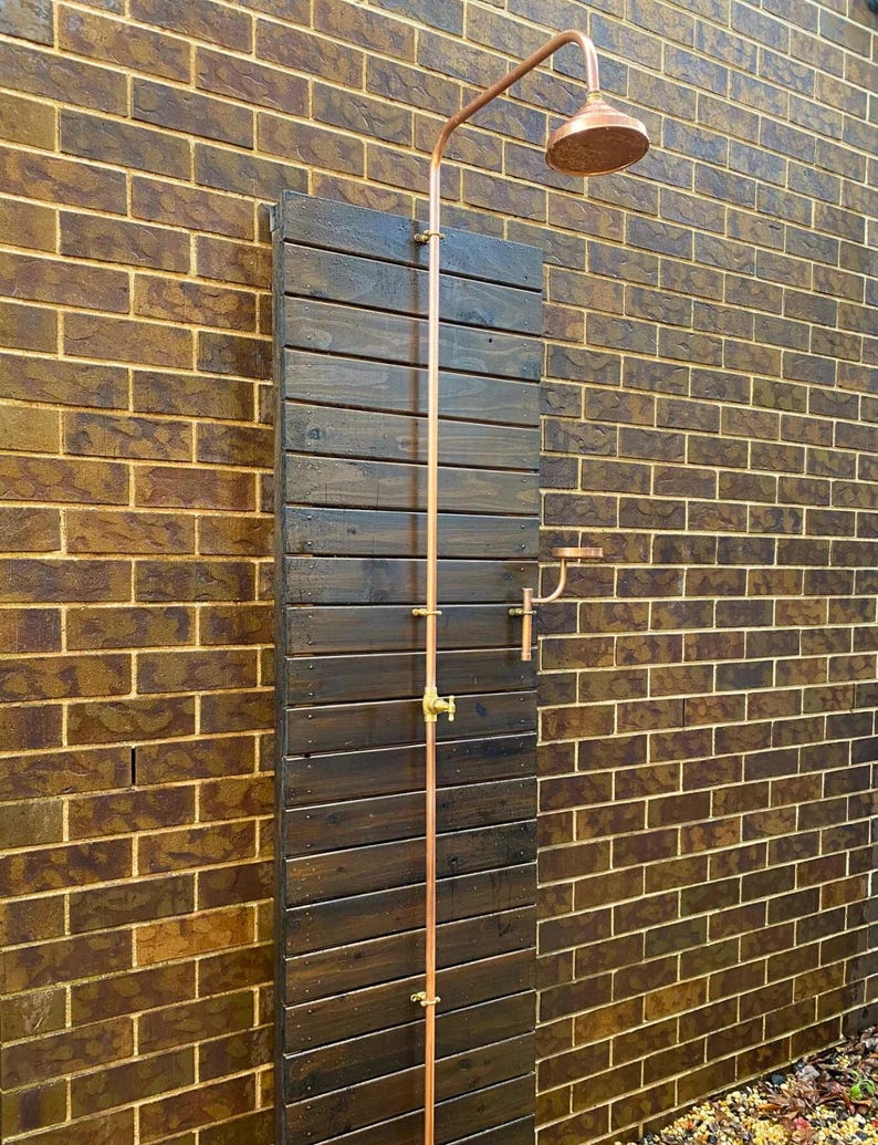 Minimalist copper and brass outdoor shower with natural patina finish