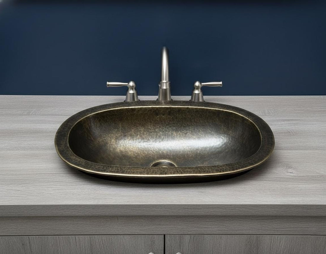 Bathroom vanity with a bronze sink and gold faucet.