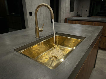 Gold sink with running water in a modern kitchen setting