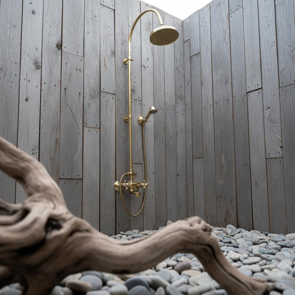 Outdoor shower setup with gold fixtures against a wooden wall.