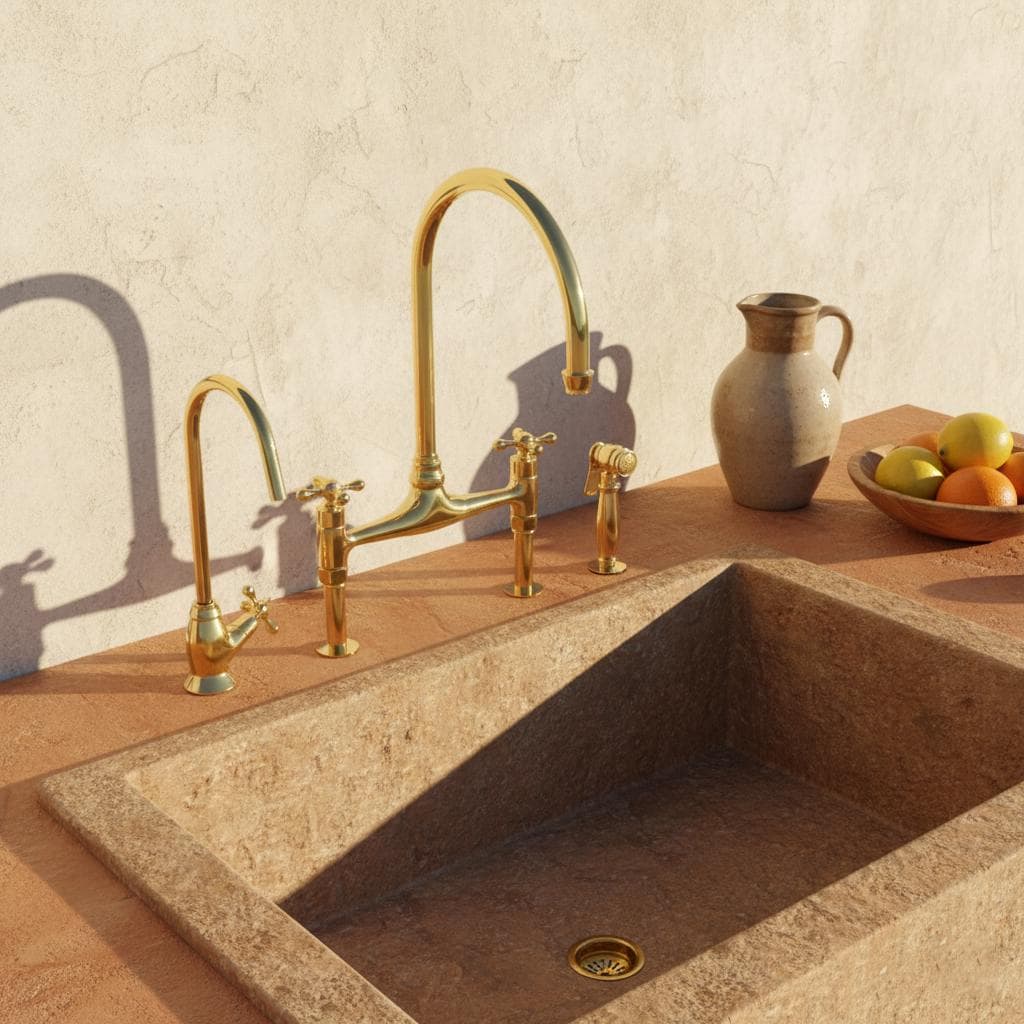 Gold kitchen faucet and sink on a beige countertop with a neutral background