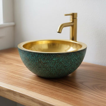 Gold faucet and speckled green sink on a wooden surface