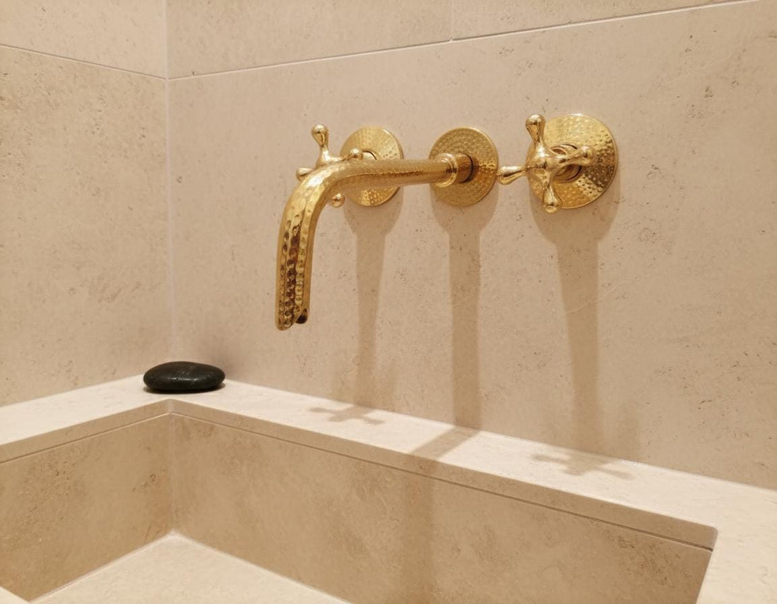 Gold faucet on a green marble sink