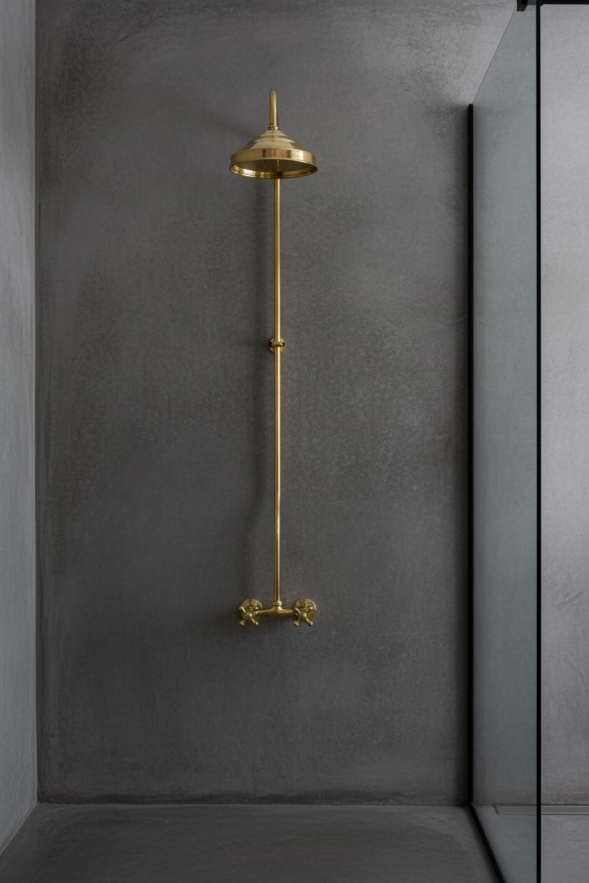 Gold shower head and handle mounted on a gray wall