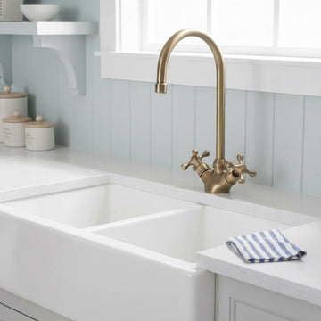 Kitchen sink with gold faucet and white countertop