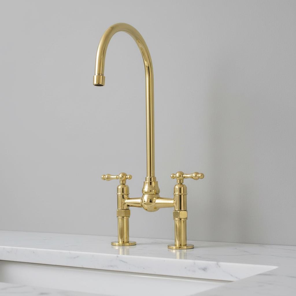 Gold kitchen faucet on a marble countertop with a gray background