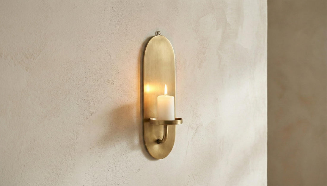 Brass wall sconce with candle on a beige wall