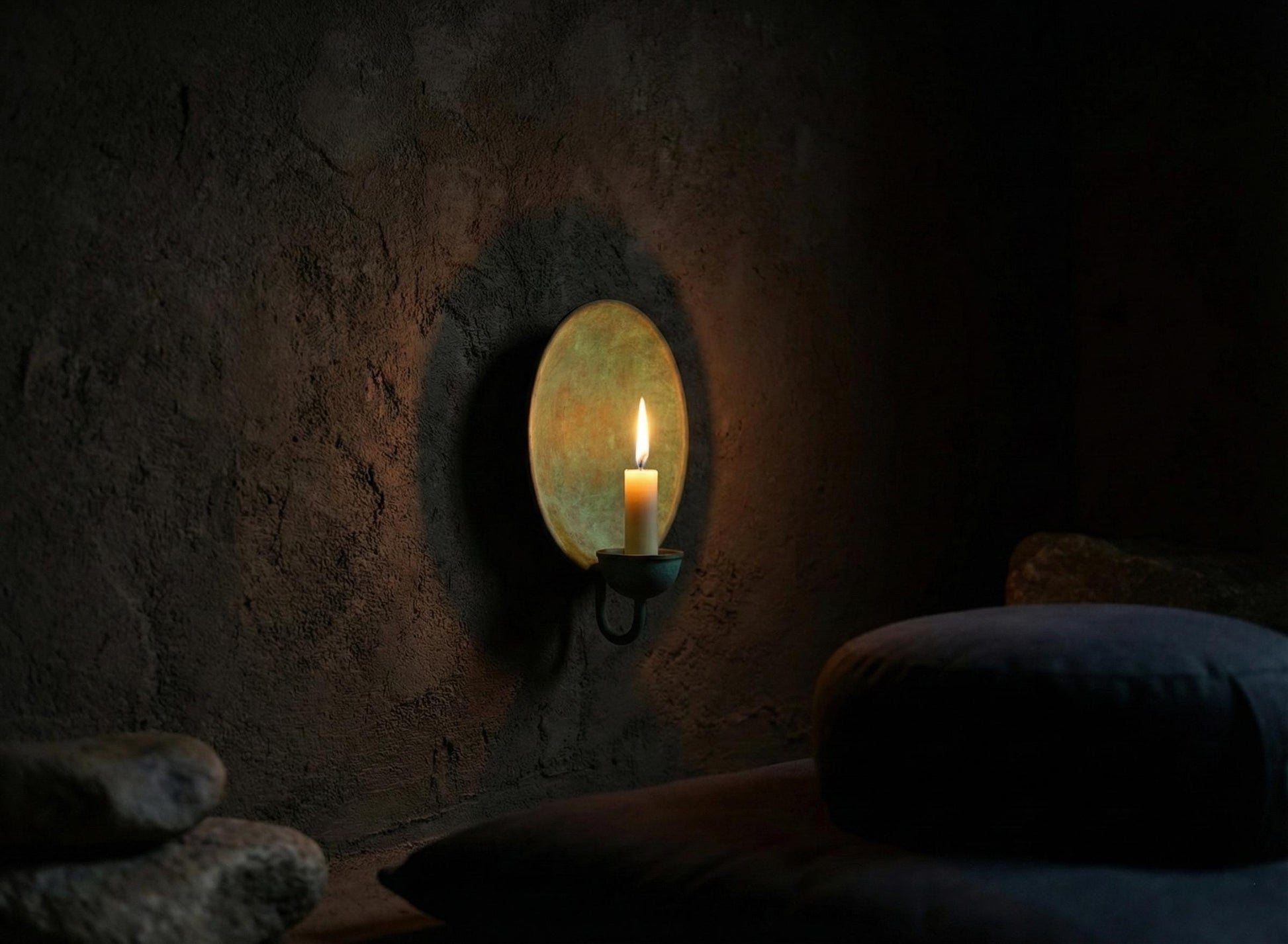 Candle in a stone wall niche with a dark background