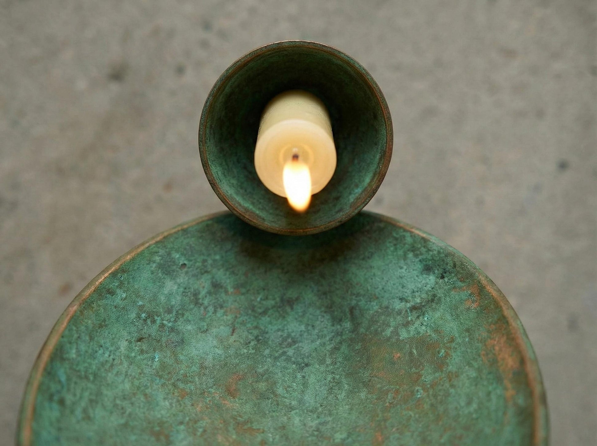 Ceramic lantern with a lit candle inside on a textured surface