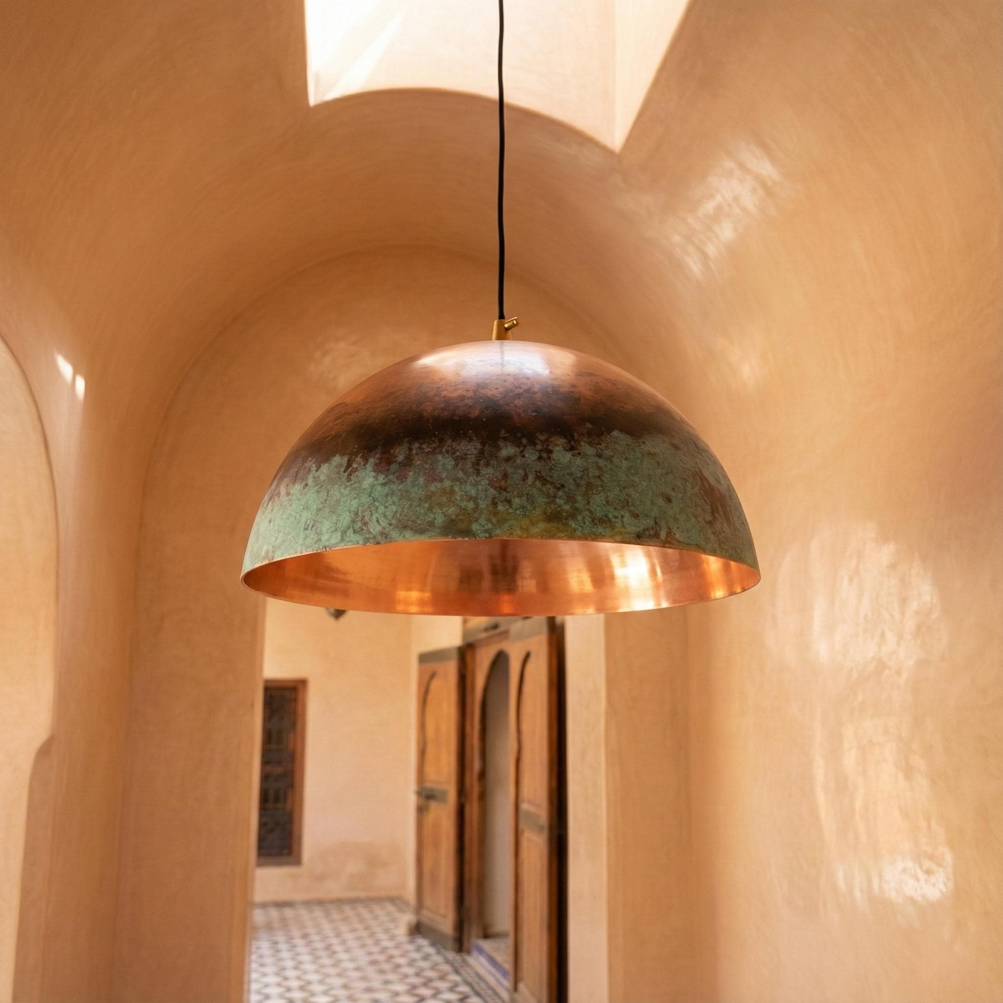 Copper pendant light hanging in a warm-toned architectural setting