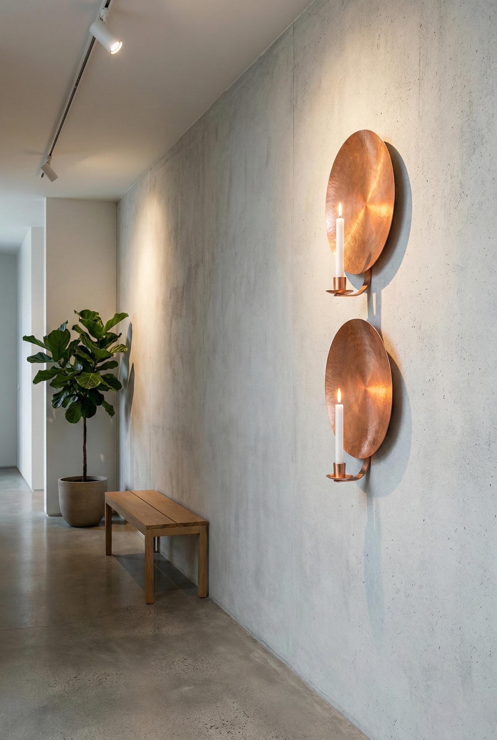 Modern interior with wall sconces, a bench, and a plant.
