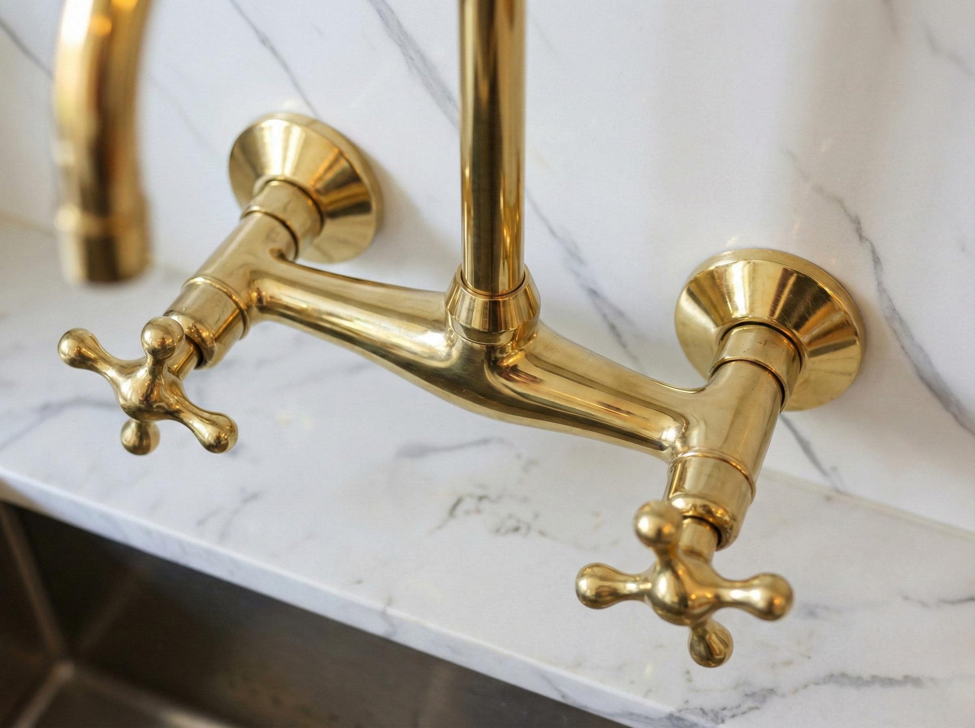 Gold kitchen faucet on a marble countertop