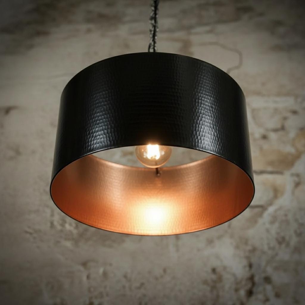 Black and copper pendant light against a textured wall background