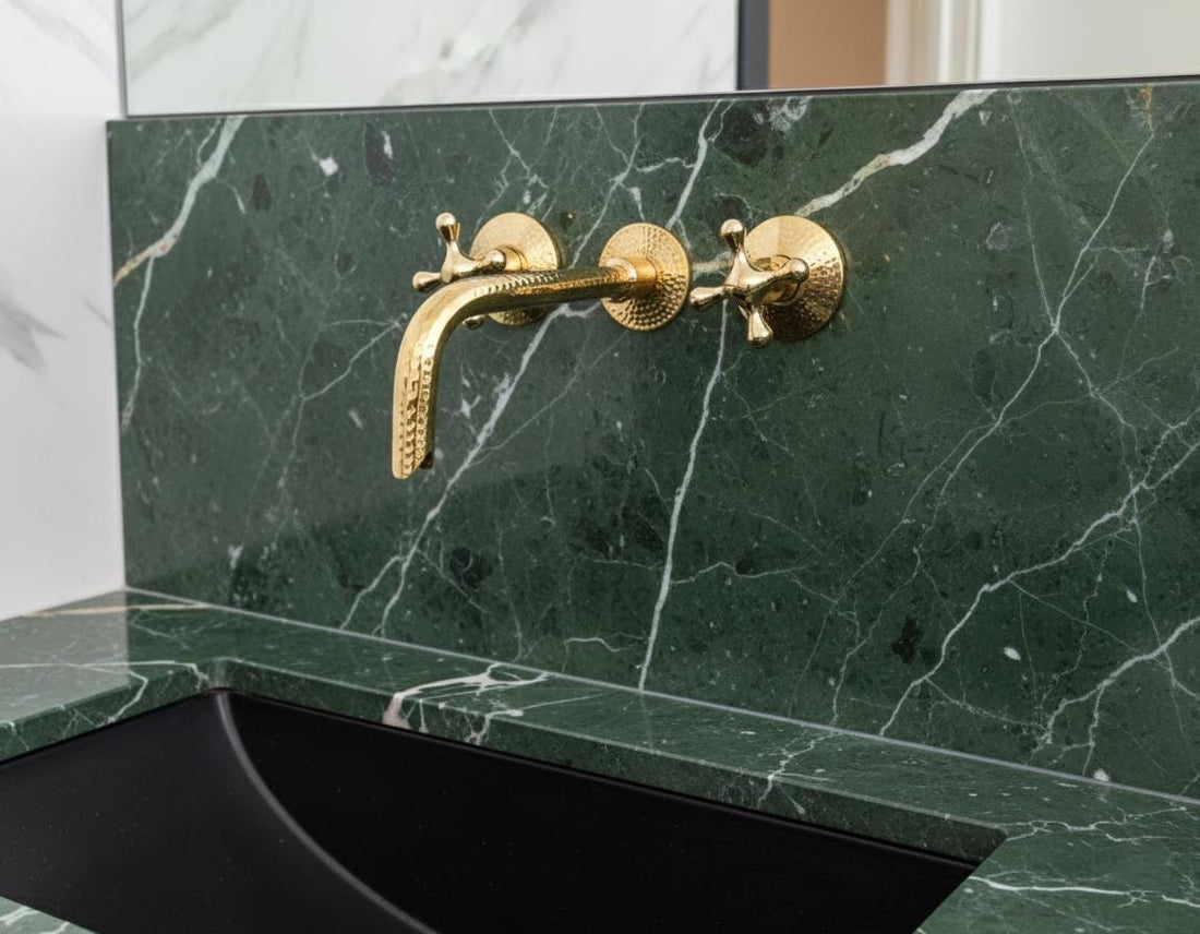 Gold faucet on a green marble sink