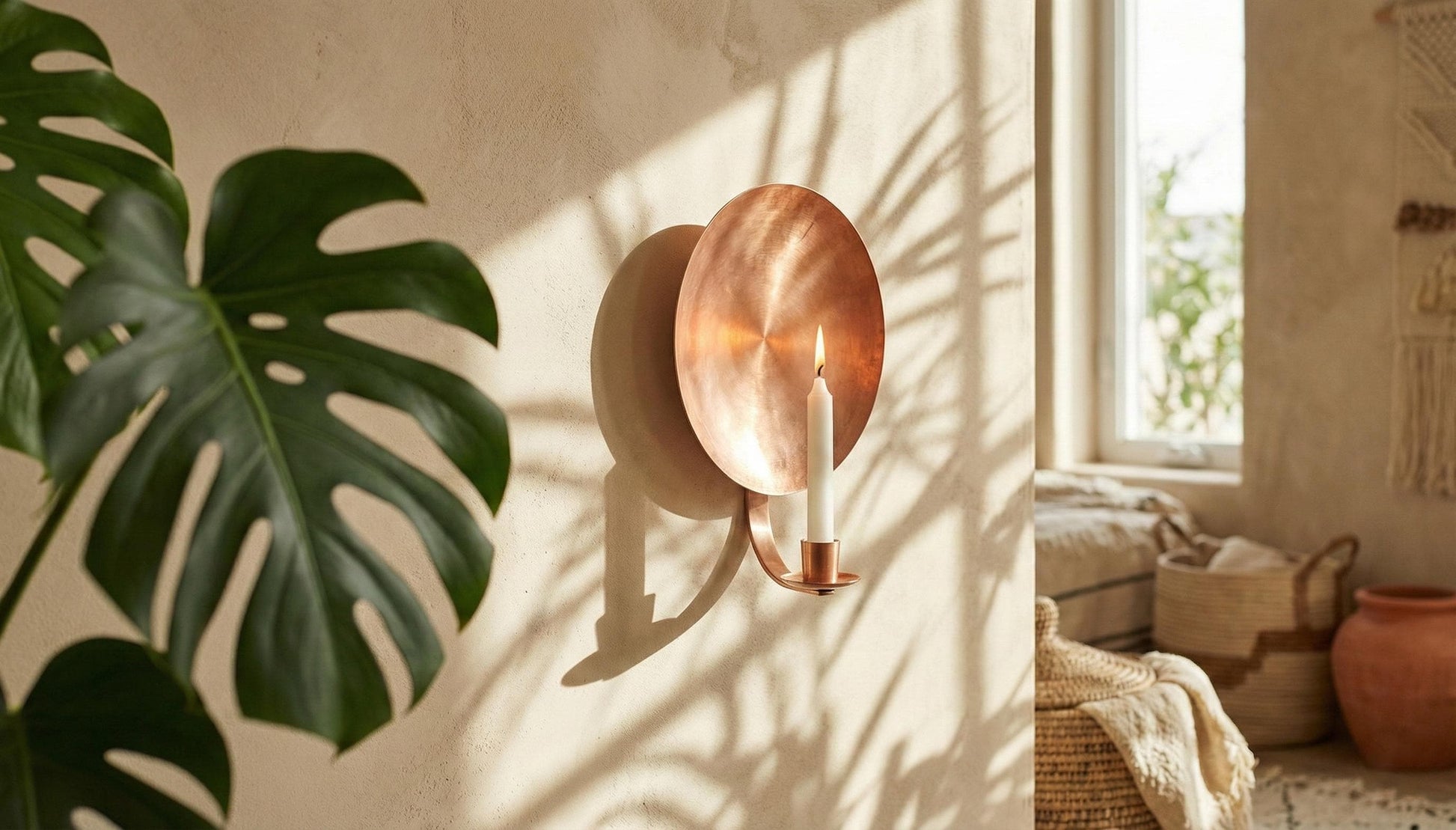 Copper wall sconce with candle in a sunlit room with plants and decor.