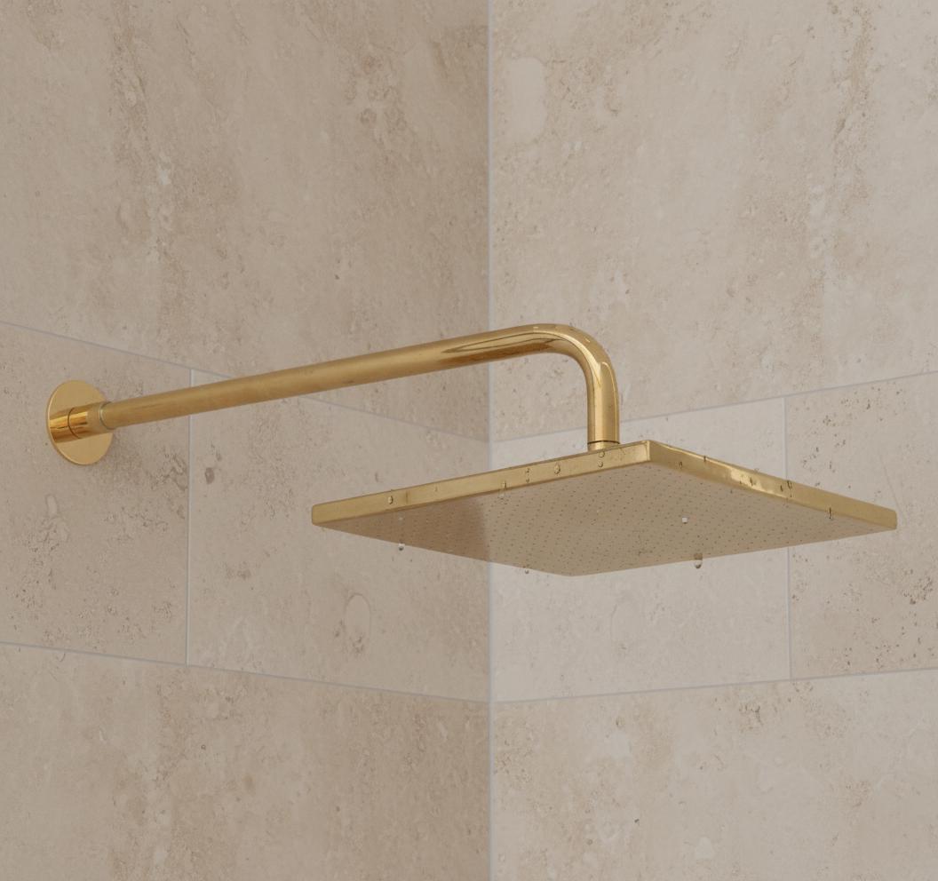 Gold shower head mounted on a tiled wall