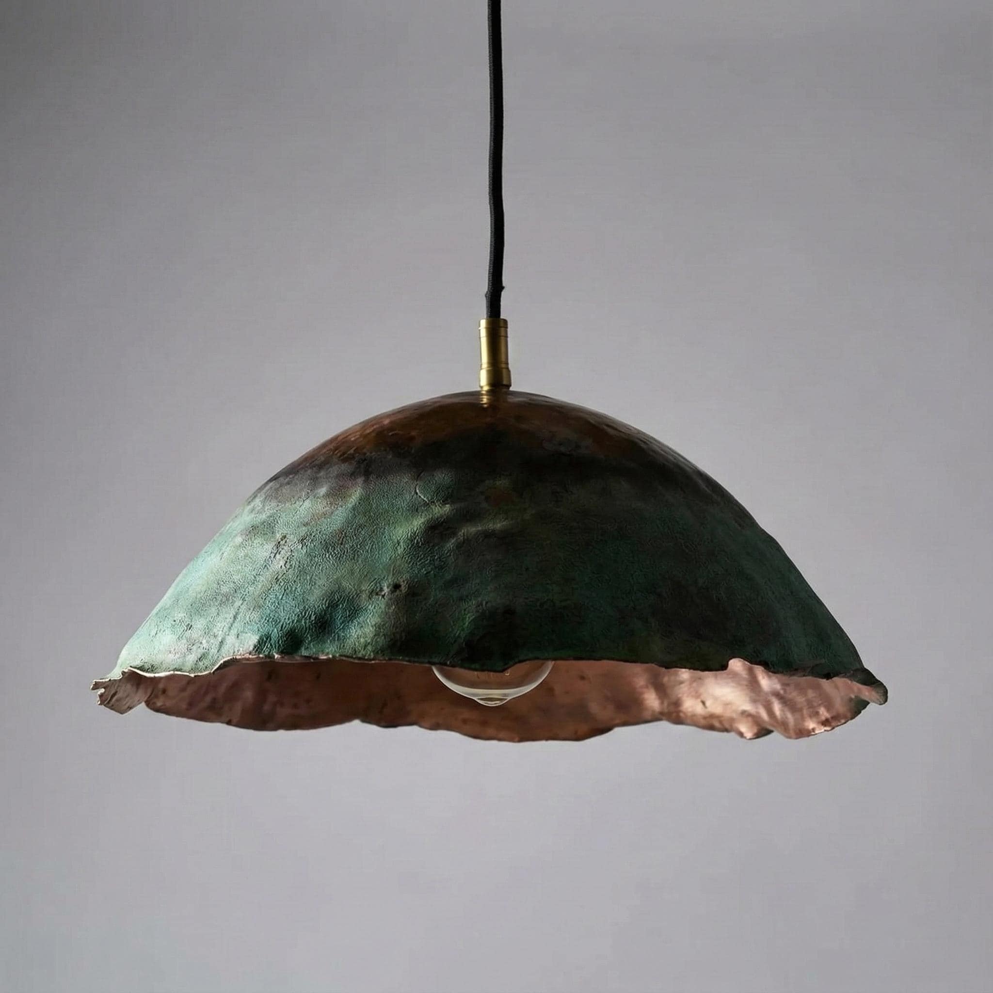 Decorative pendant light with a green and copper finish on a gray background