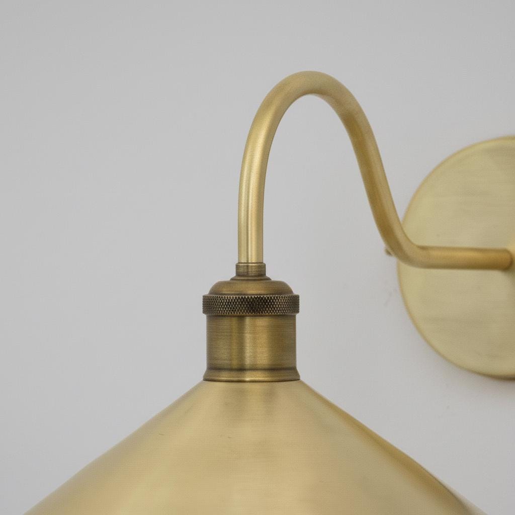 Brass wall-mounted light fixture on a plain background