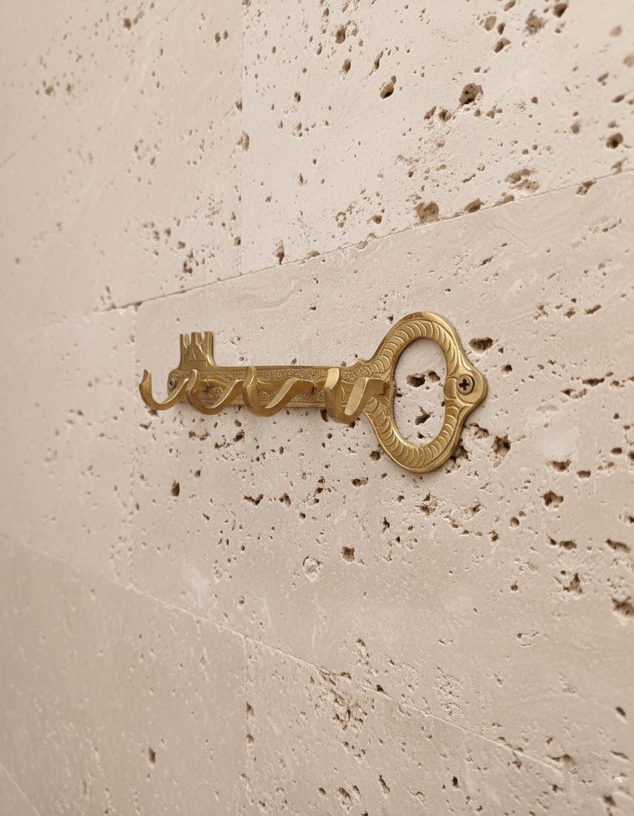 Decorative brass key on a textured beige surface