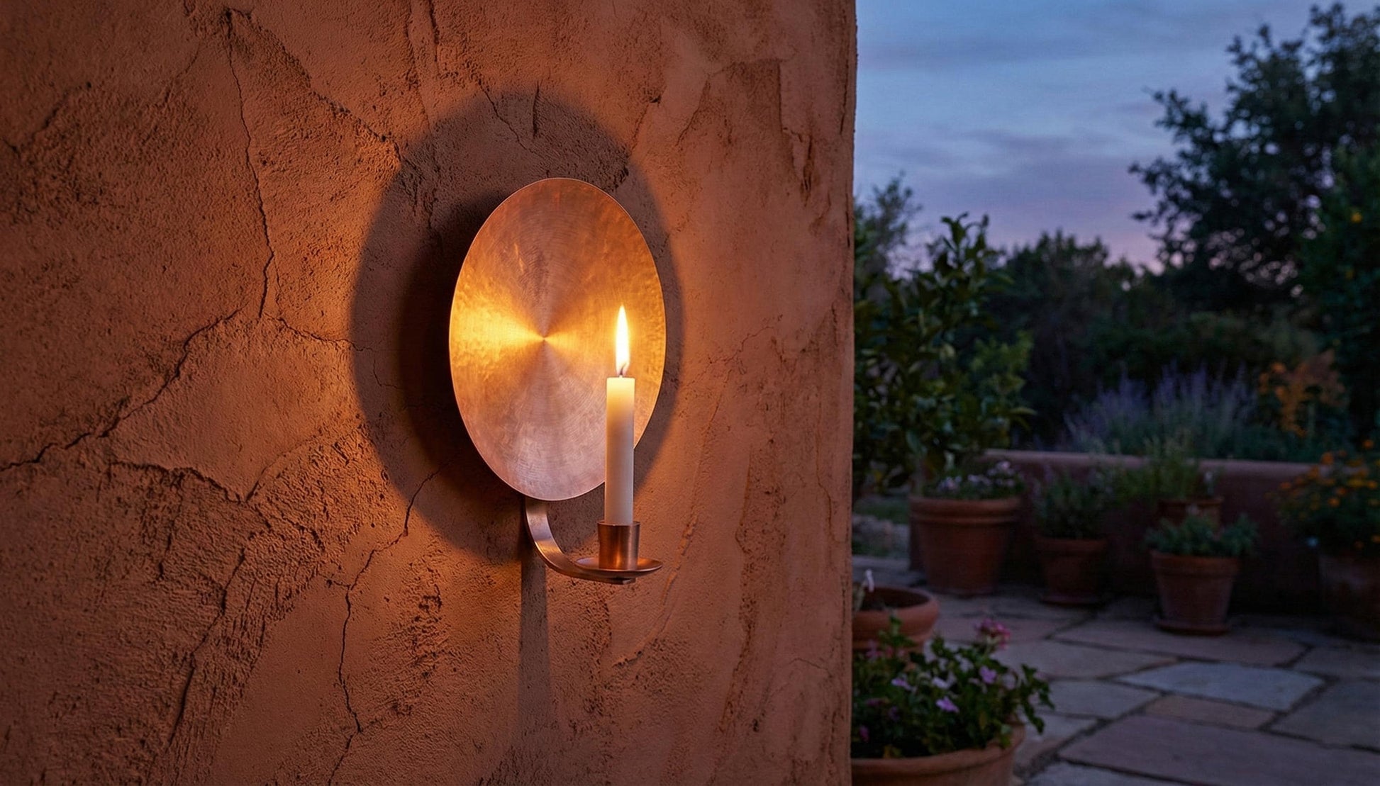 Candle in a wall-mounted holder on a stone wall with outdoor setting