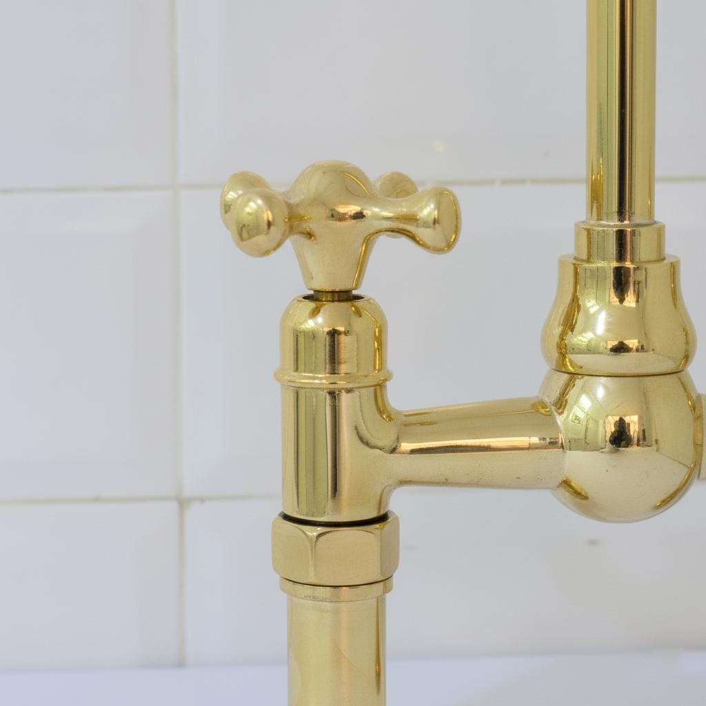 Gold faucet against a white tiled wall