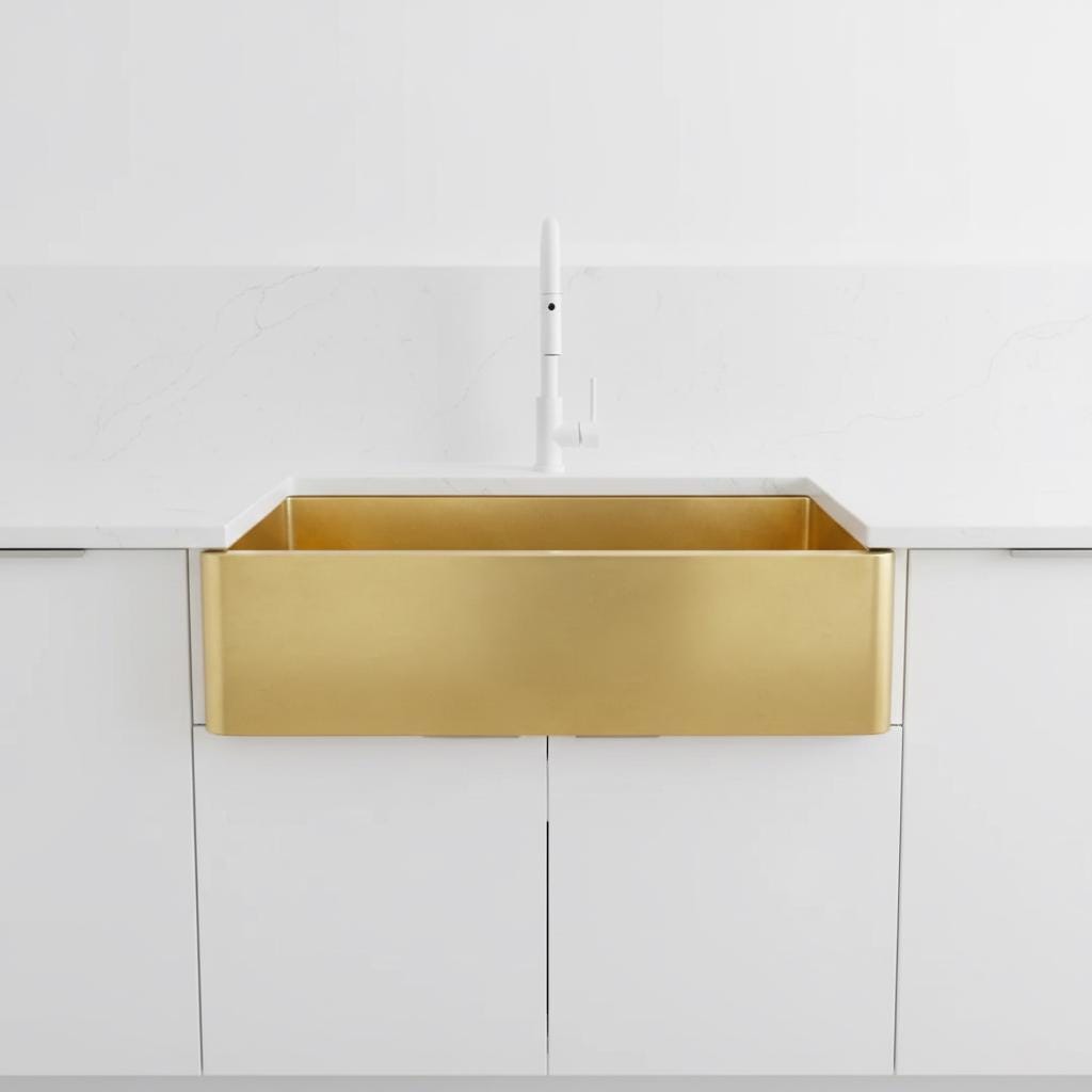Gold kitchen sink in a white kitchen setting