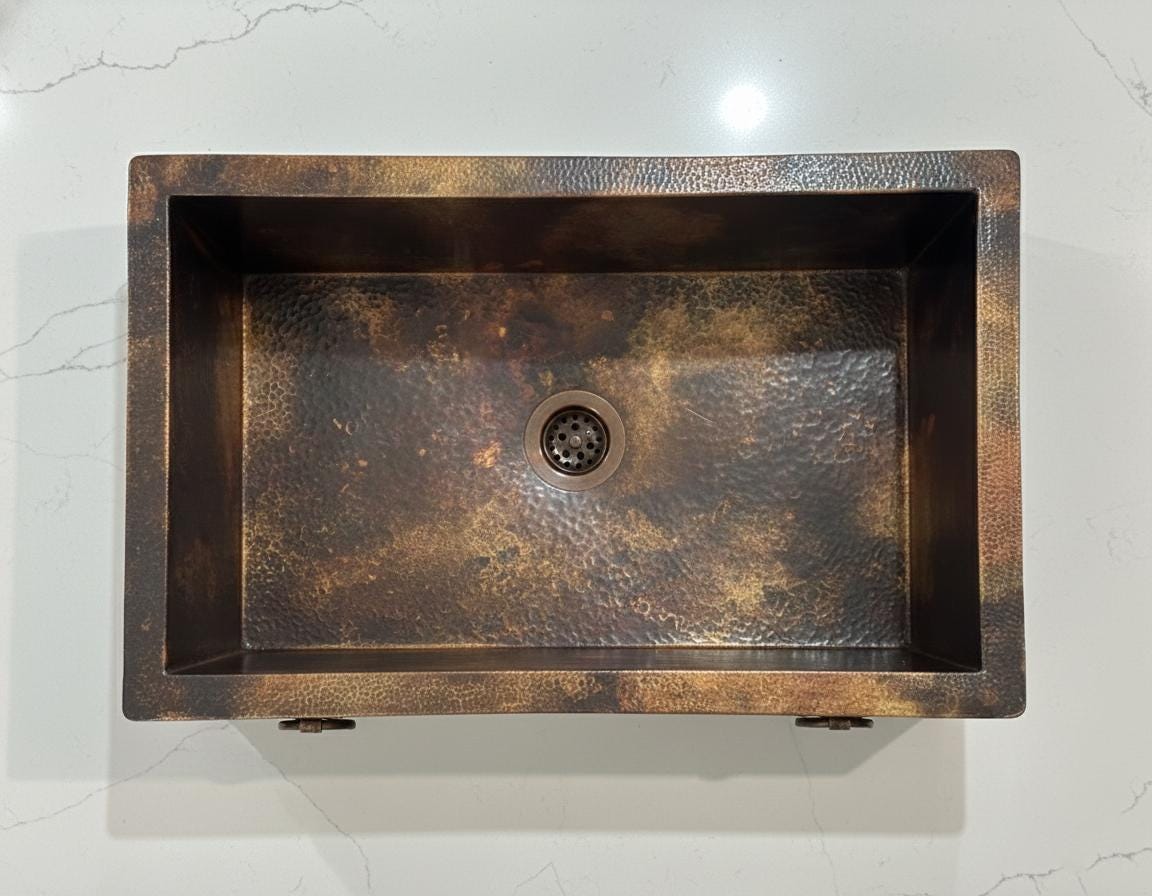 Copper sink with textured surface on a light gray background