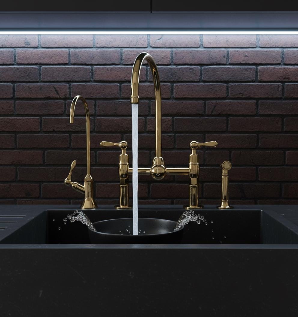 Gold kitchen faucet with a black sink against a brick wall.