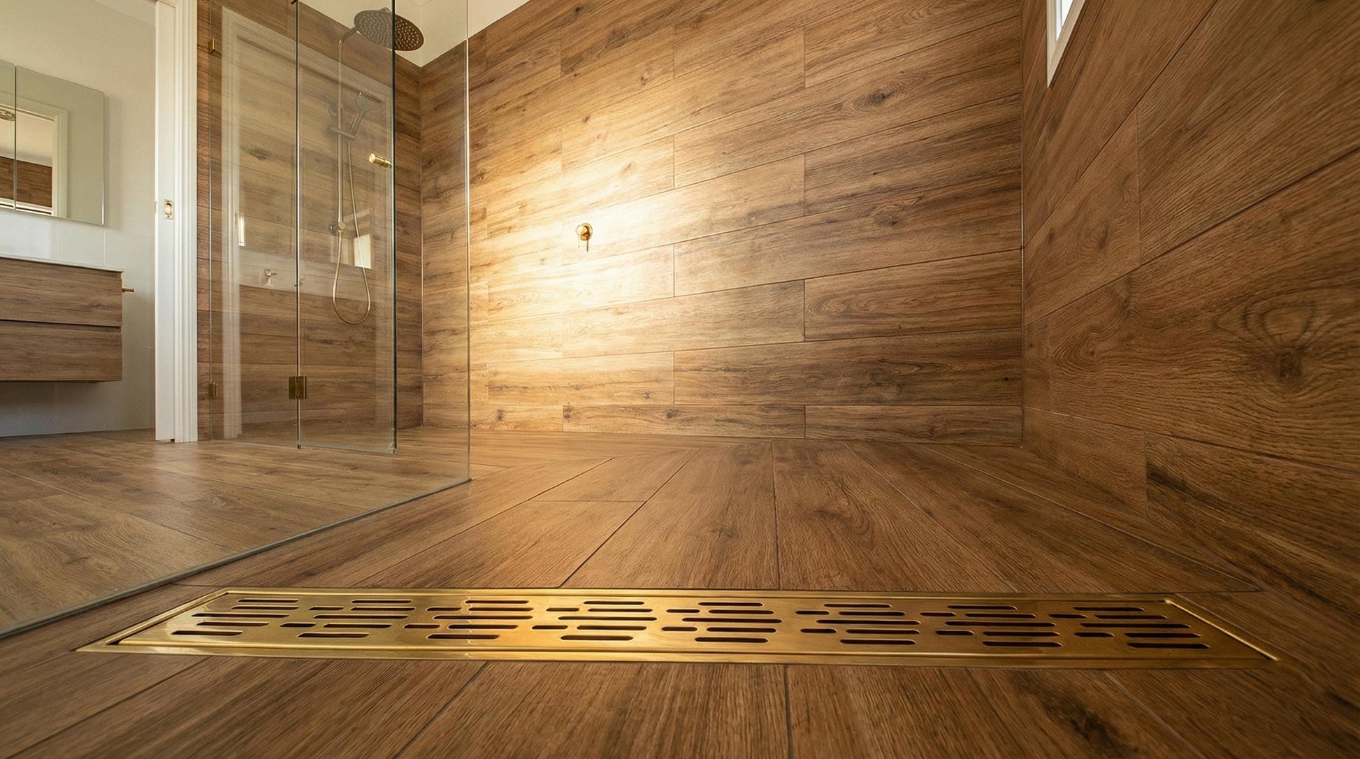 Wooden bathroom with a shower area and floor drain cover.