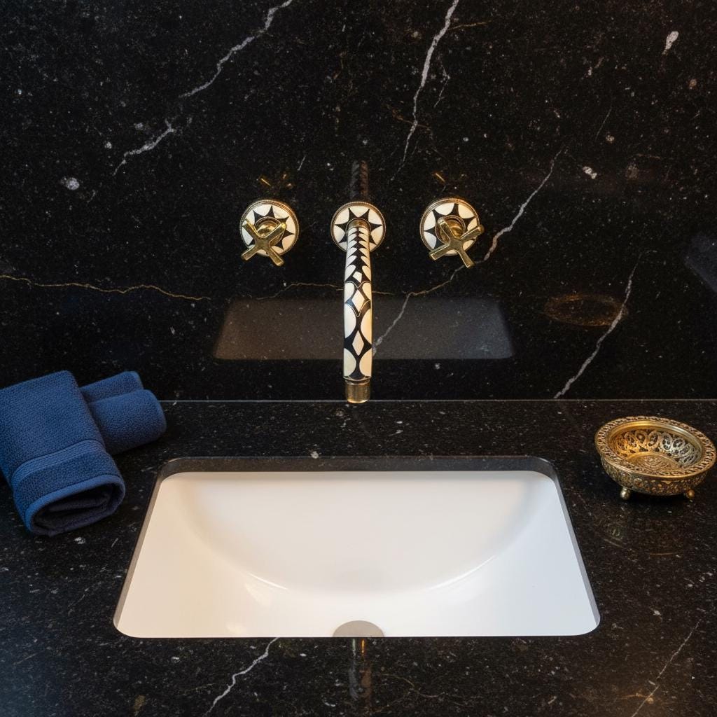 Bathroom sink with decorative faucet on a black marble countertop