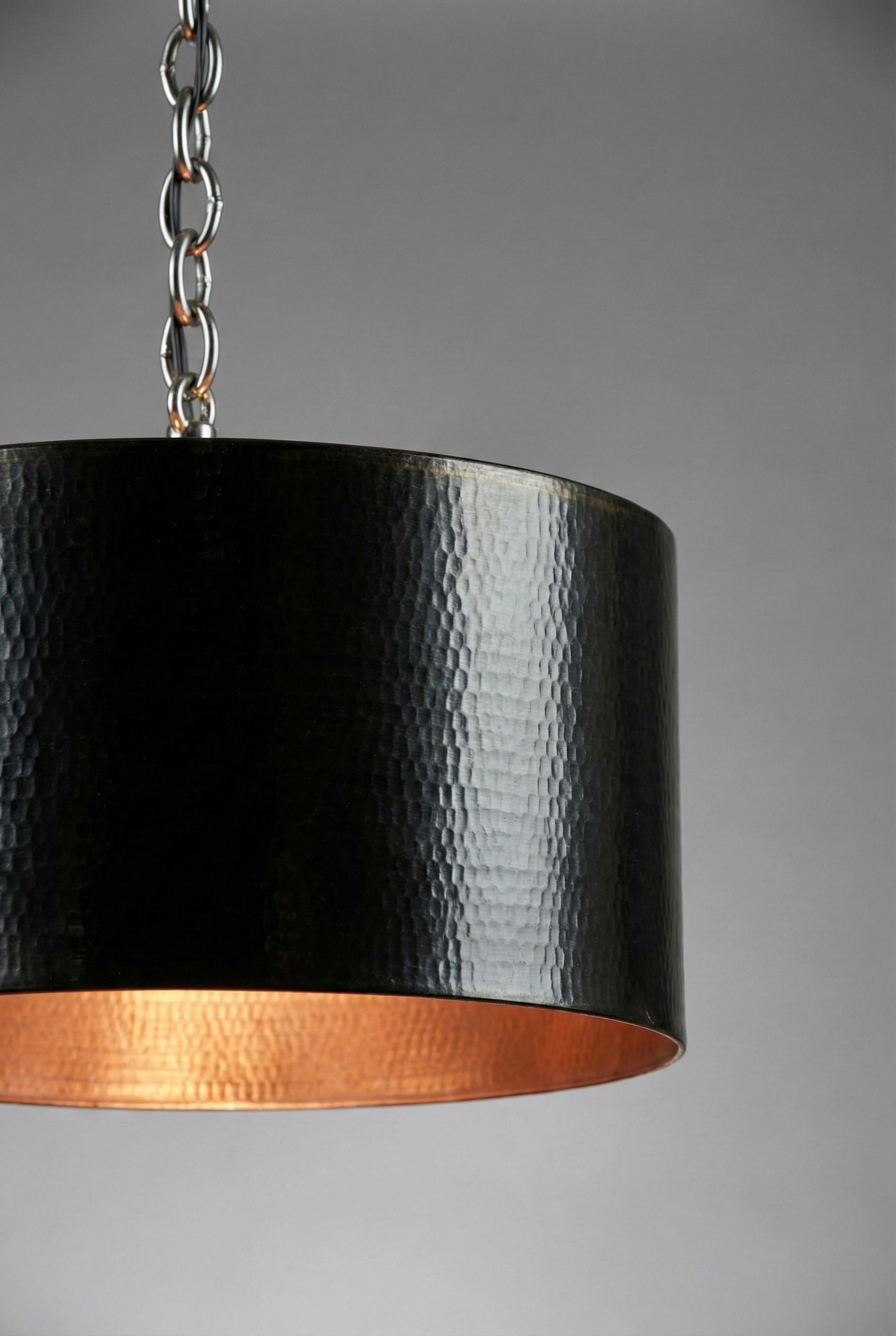 Black and copper pendant light against a gray background