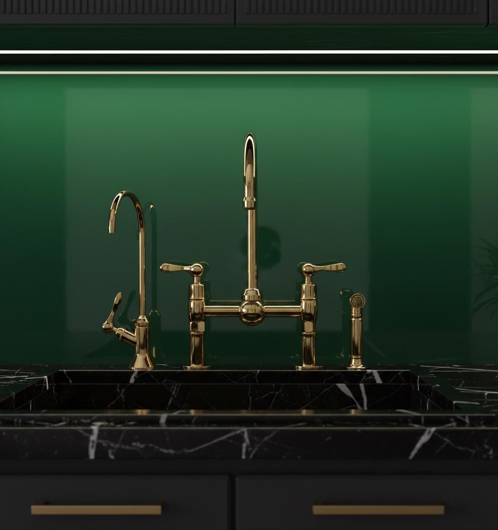 Gold kitchen faucet on a black marble countertop with a green wall background