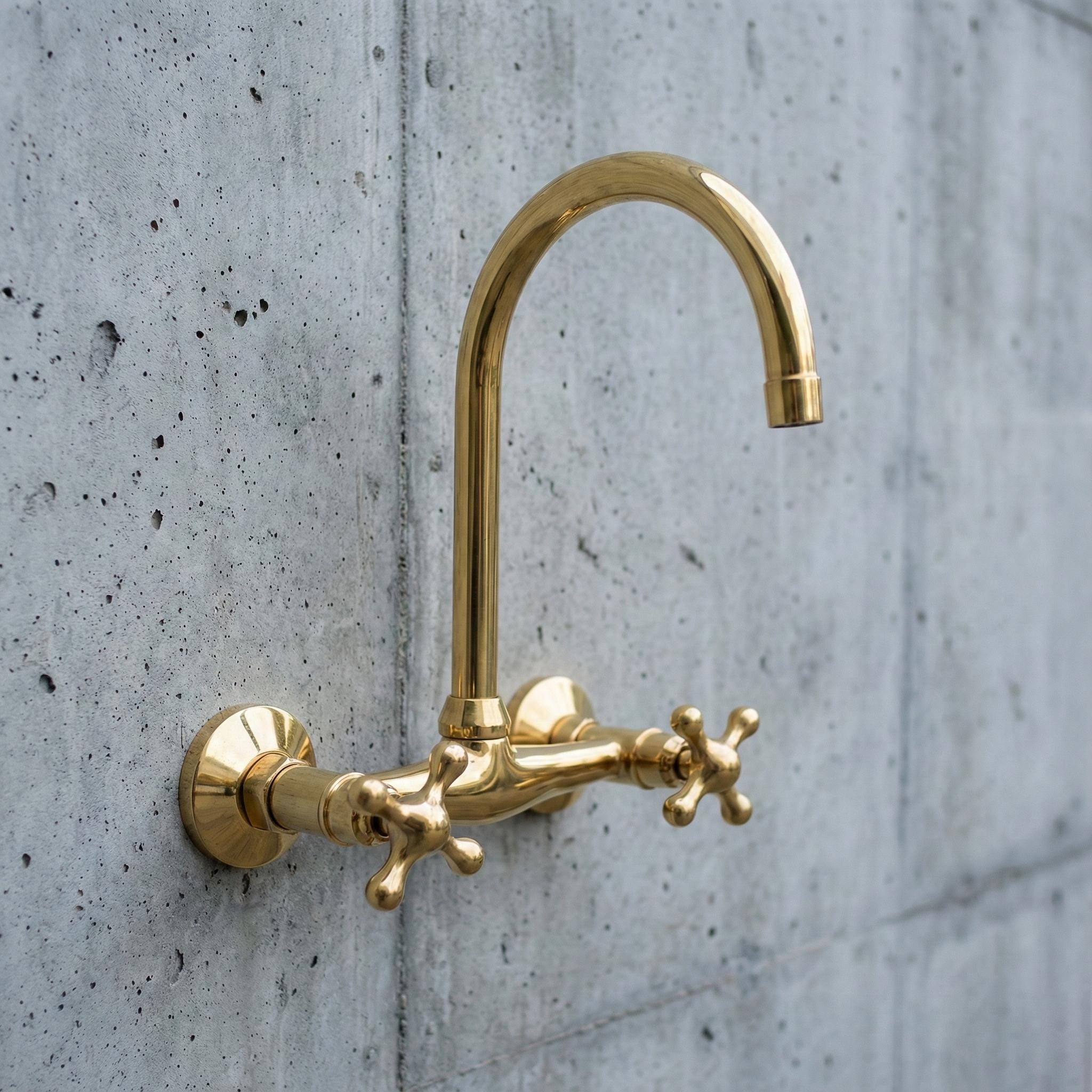 Gold faucet mounted on a concrete wall