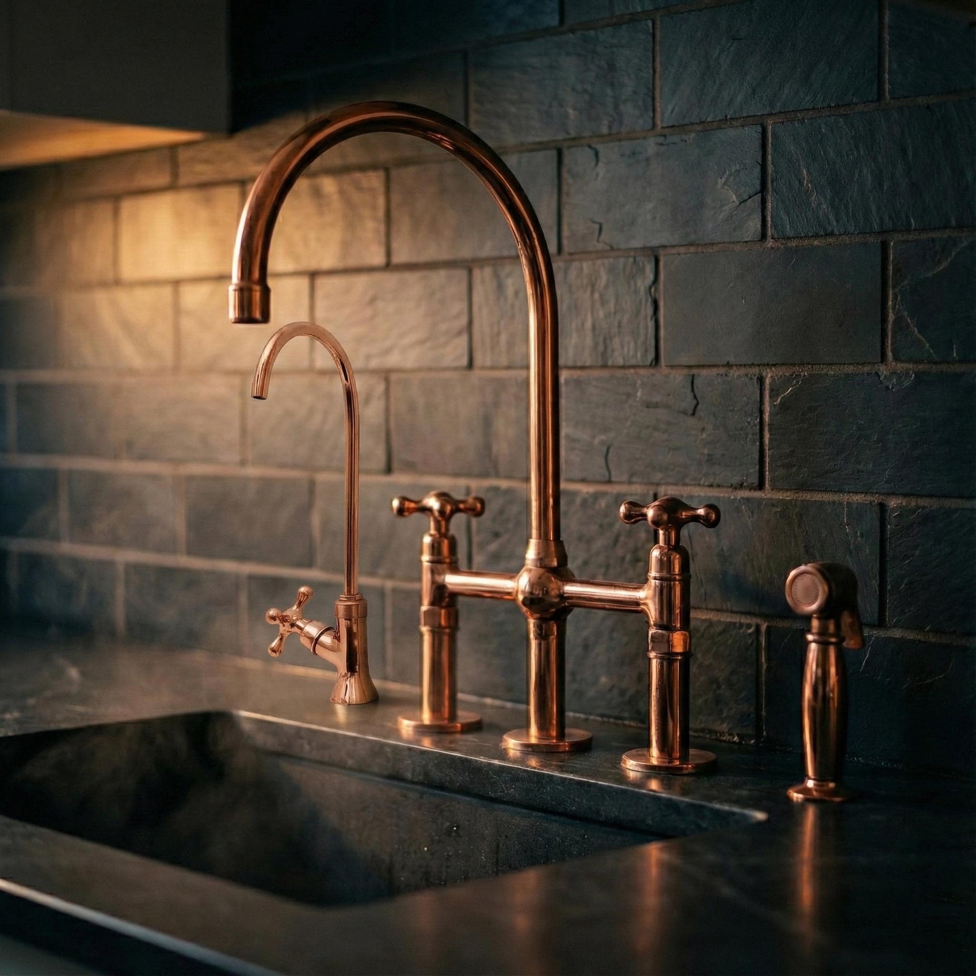 Bronze faucet and handles on a kitchen sink with a tiled wall background