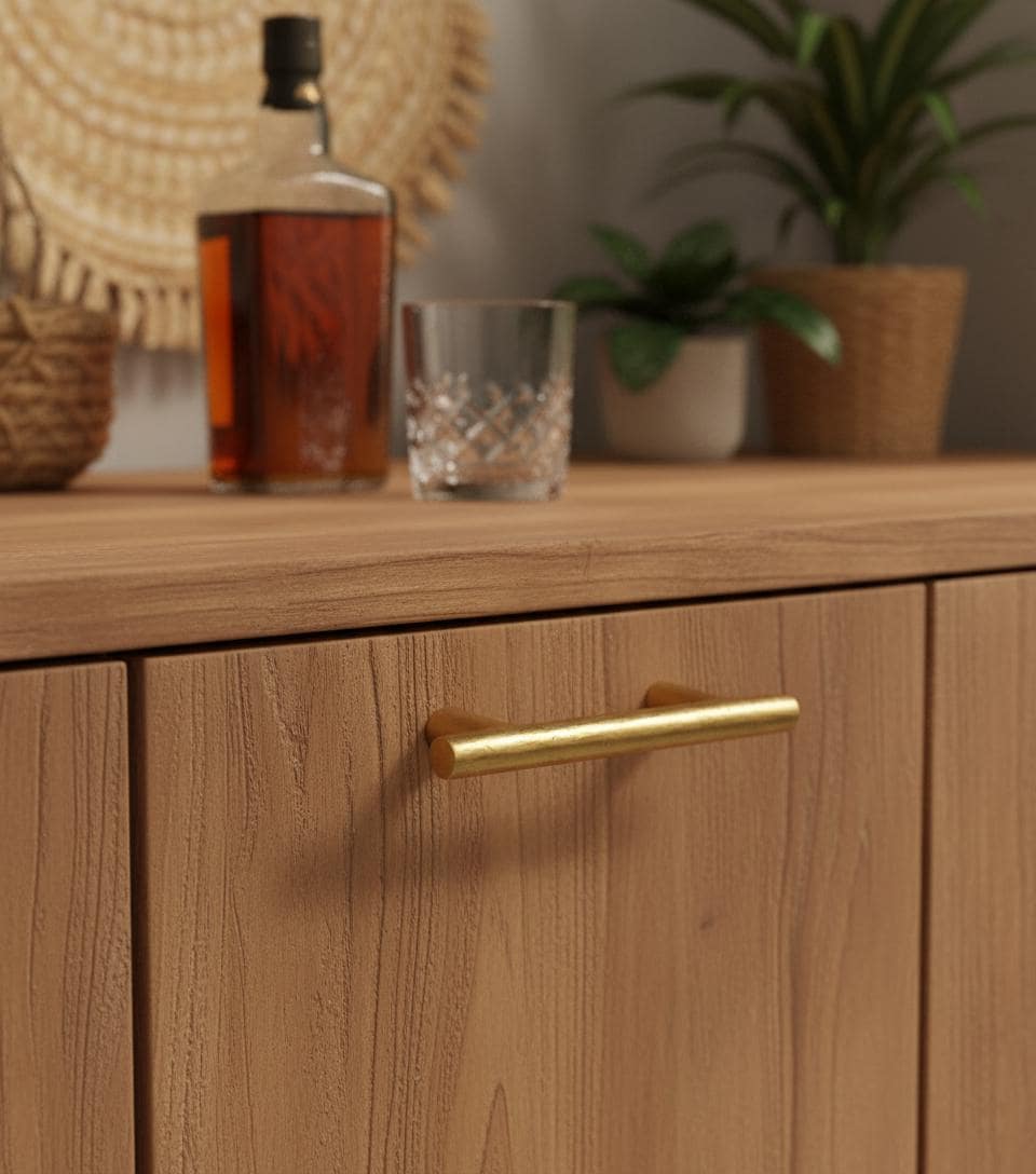 Wooden cabinet with a gold handle, bottle, and glass on top