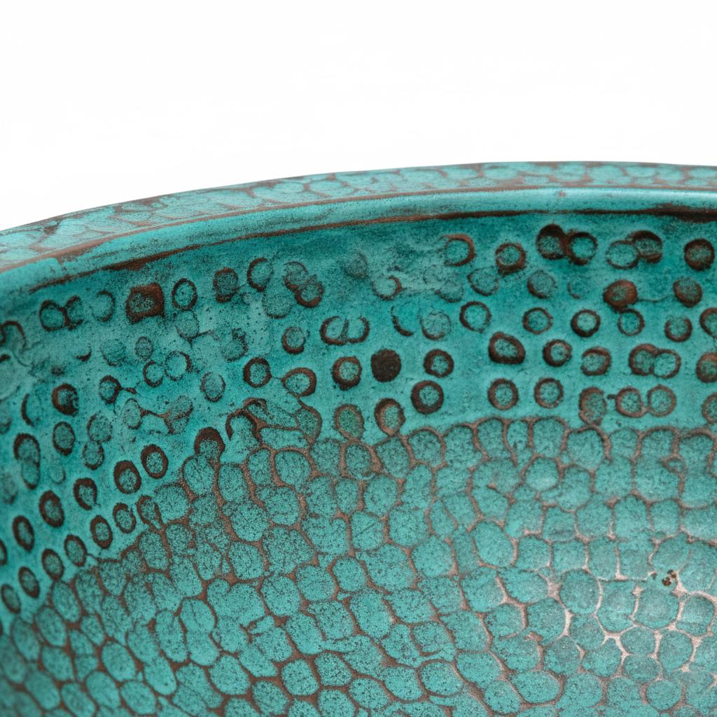 Close-up of a textured turquoise ceramic bowl on a white background