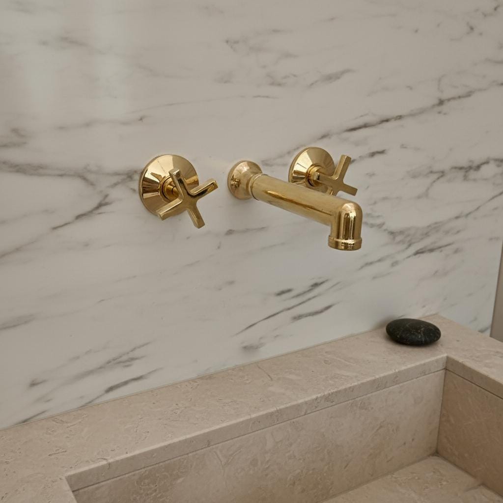 Gold faucet and handles on a marble wall