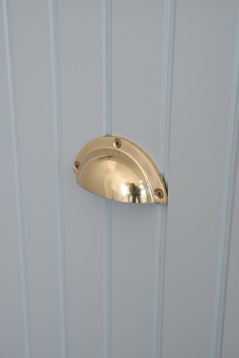 Gold door handle on a white paneled door