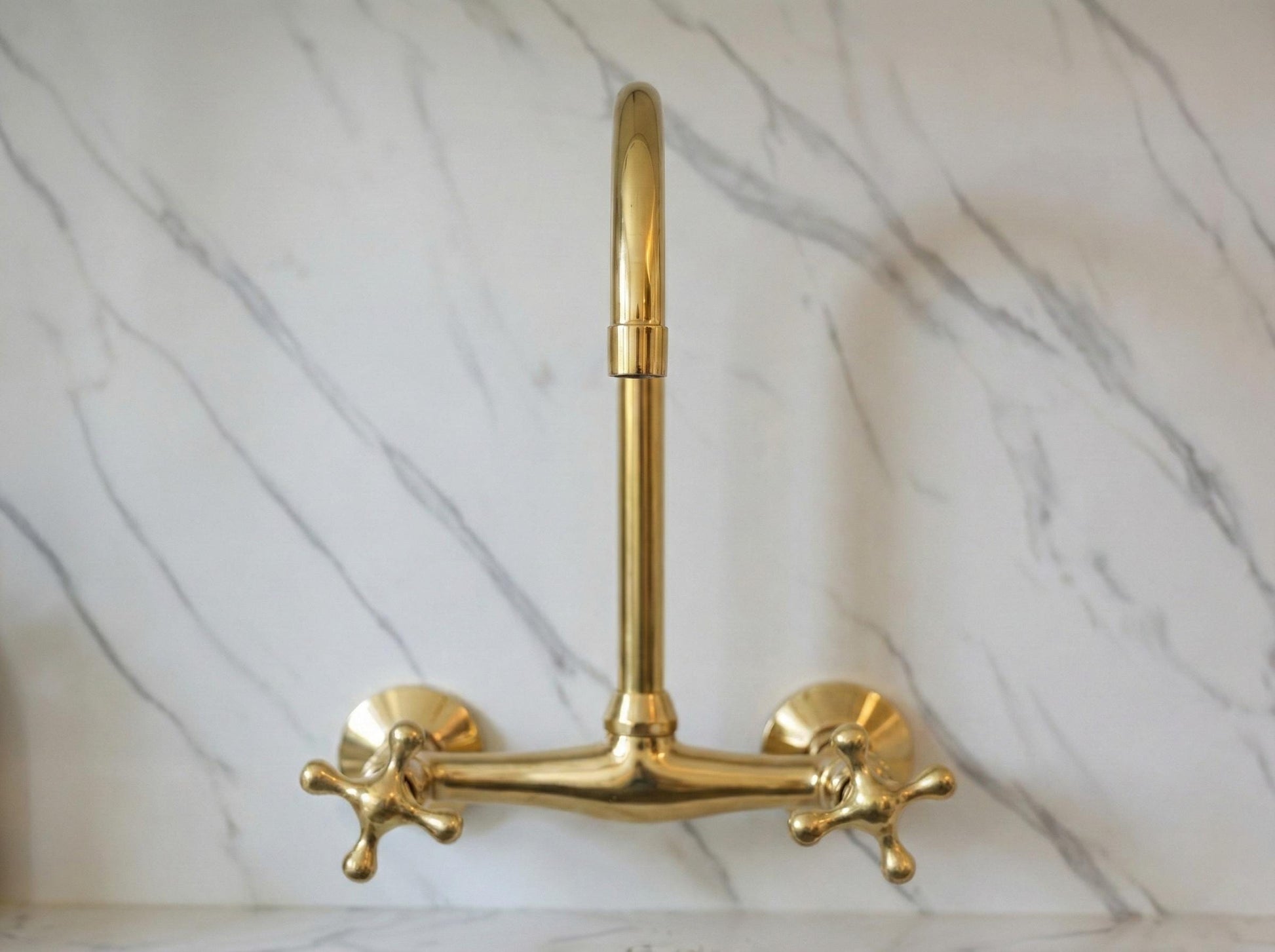 Gold faucet on a marble wall