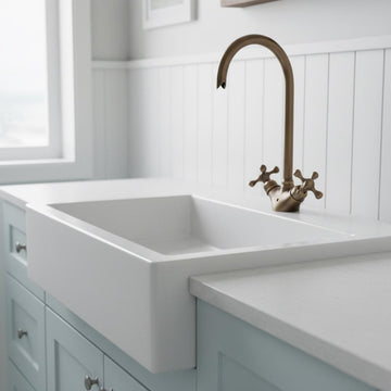 White kitchen sink with bronze faucet in a modern kitchen setting