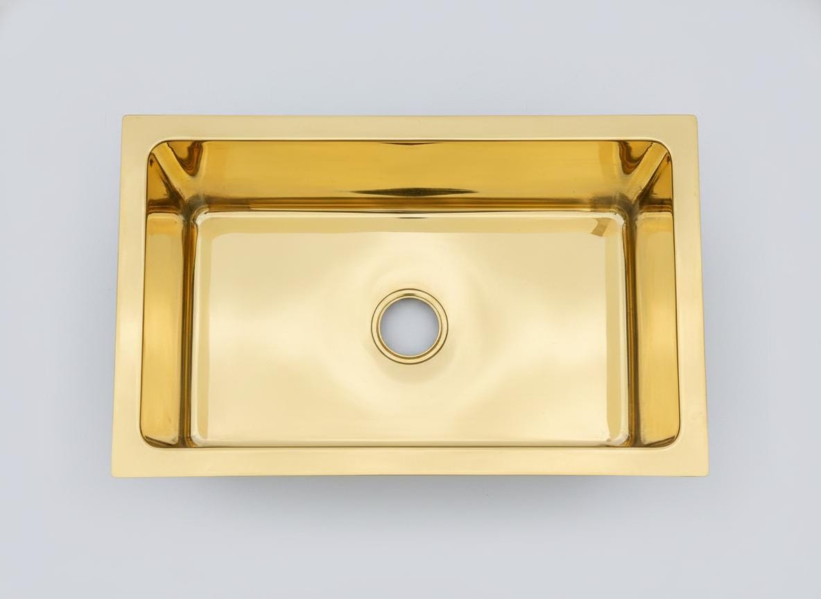 Gold kitchen sink on a light gray background