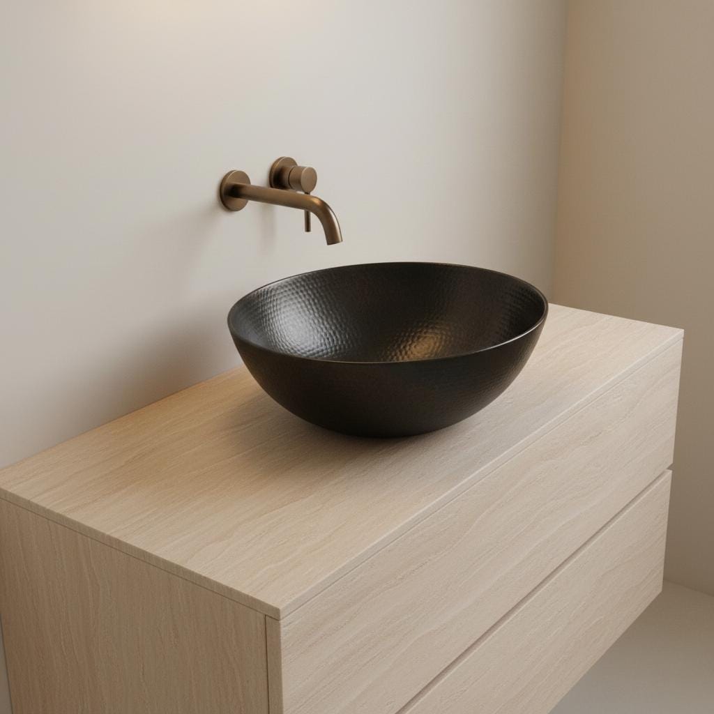 Black round sink on a wooden vanity with a wall-mounted faucet.
