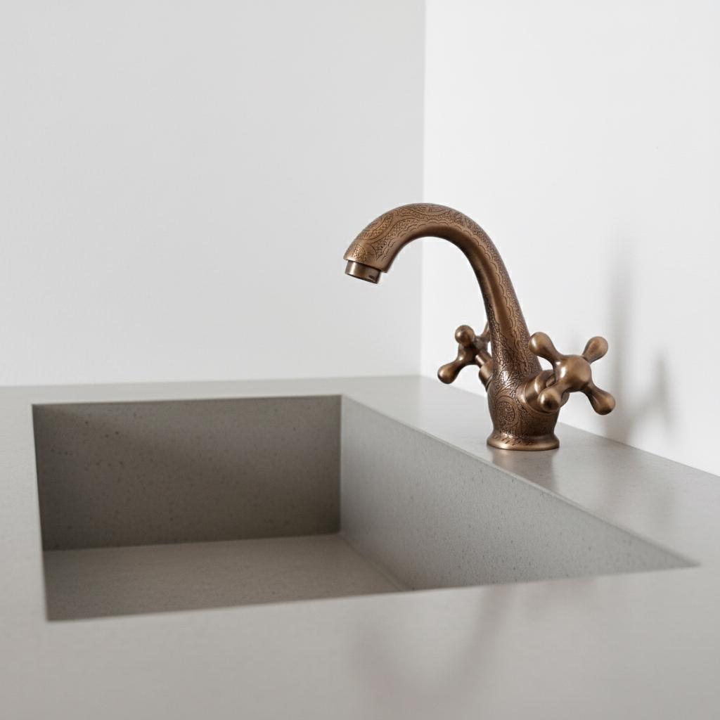 Bronze faucet on a modern kitchen sink with a white background