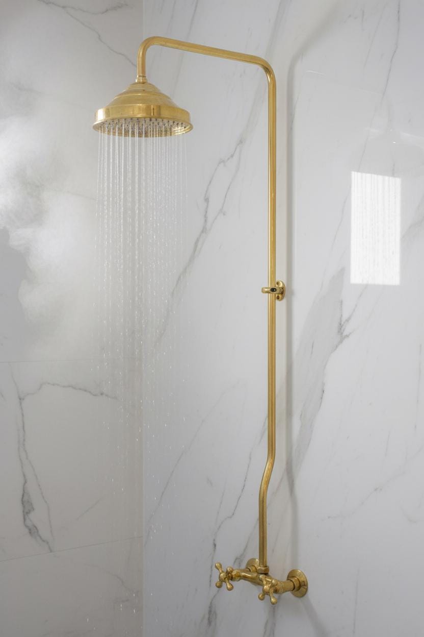 Gold shower head and hose on a marble wall