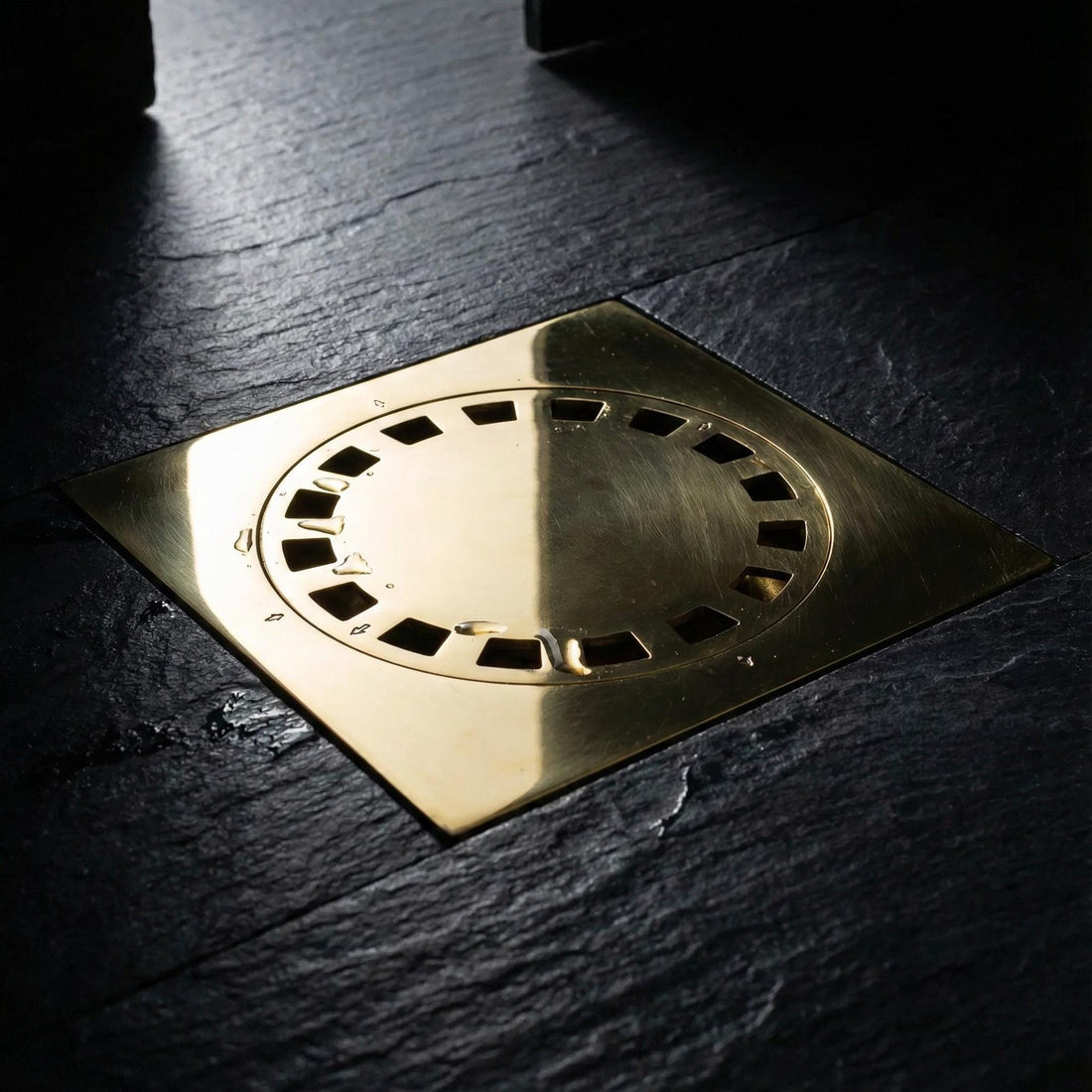 Metallic shower drain cover on a tiled bathroom floor