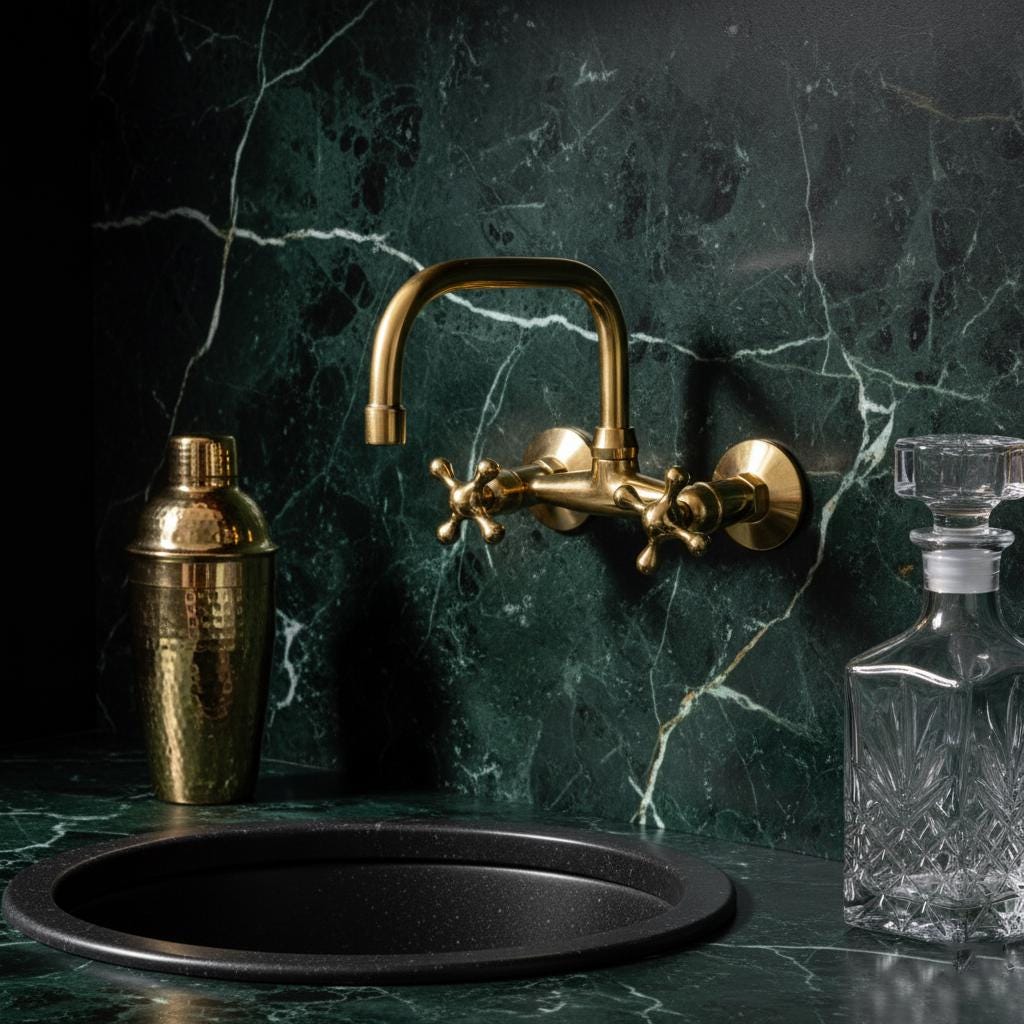 Gold faucet on a green marble wall with a black sink and bar shaker.