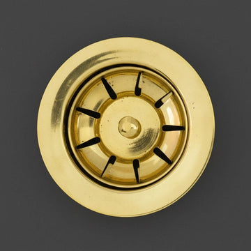 Gold sink drain with black rubber washers on a dark gray background
