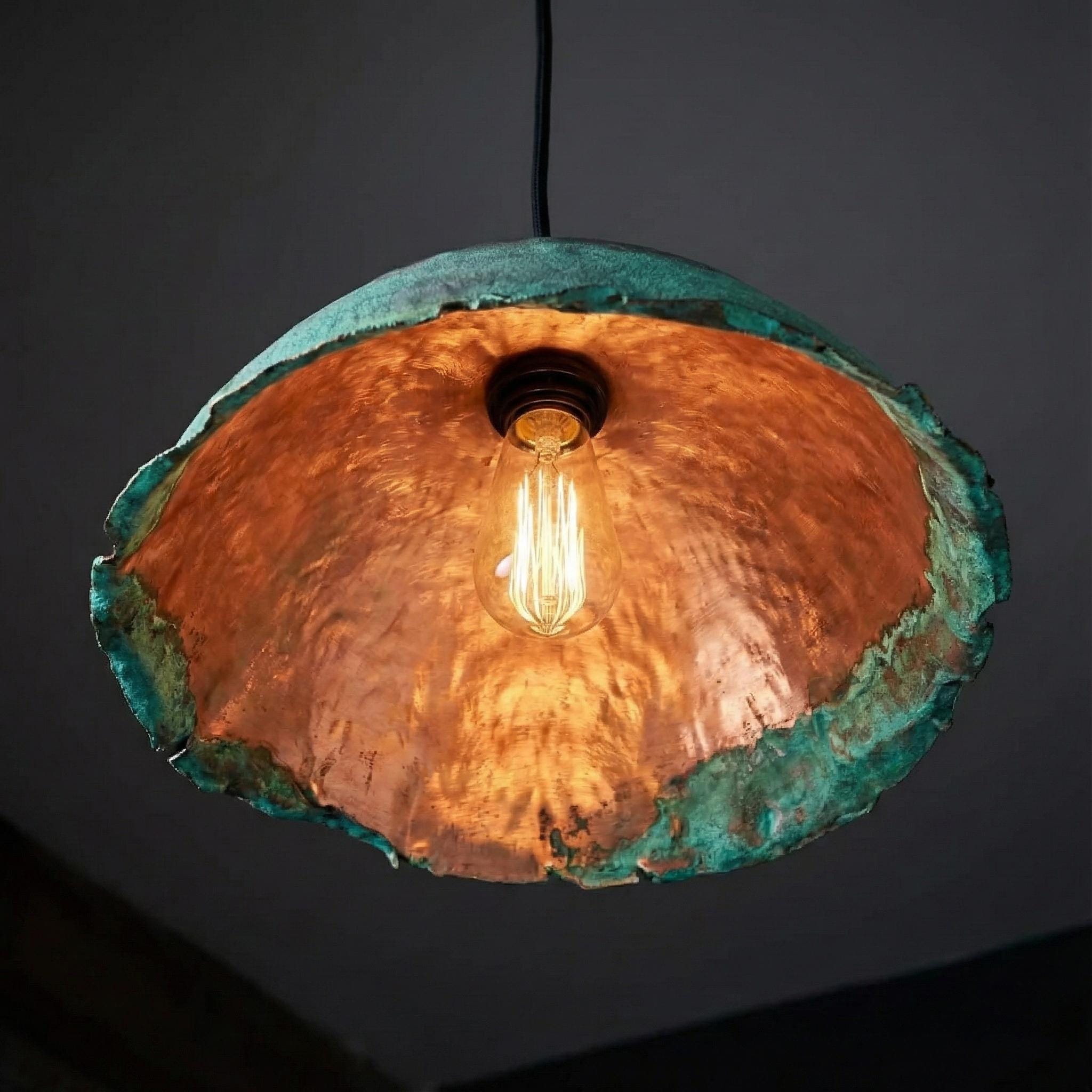 Copper pendant light with a textured finish on a dark background